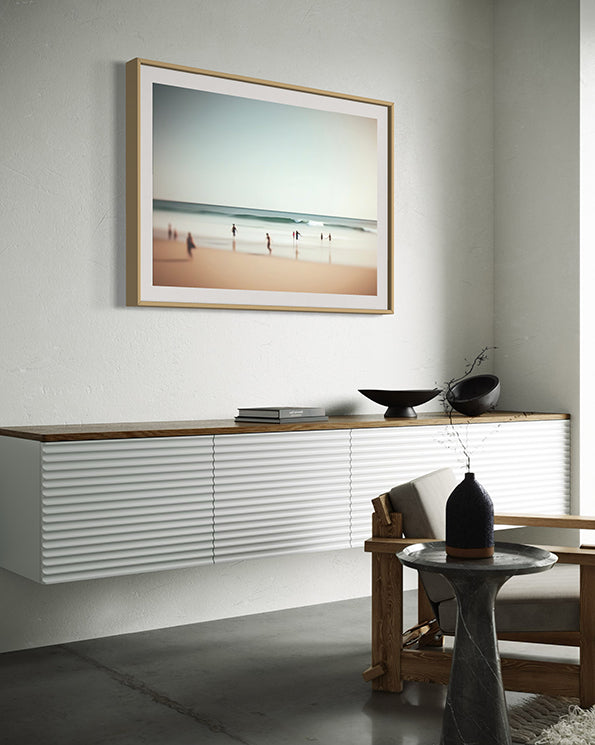 Joyful moments unique wall art print with muted beach scene with children running on the waters edge. wall art print hanging in living room.