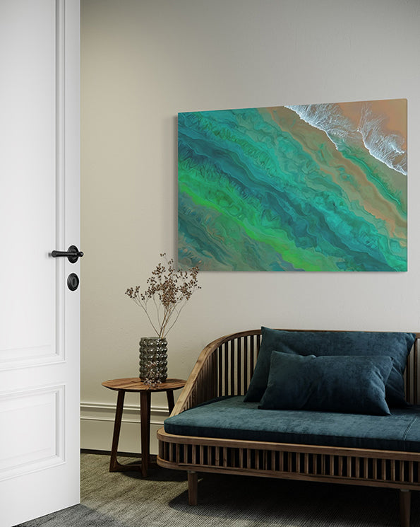 tidal whispers unique wall art print, waves gentle lapping at the shore in green and aqua tones. wall art in living room above a blue green coastal lounge.