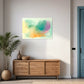 unique wall art print with beautiful pastel green orange and purple shapes and colours, abstract artwork hanging above low lying cupboard in living room