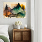 botanical wall art print featuring mountains, pine trees and digital paint splattering, wall art hanging in a bedroom above a bedside table and bed with white linen