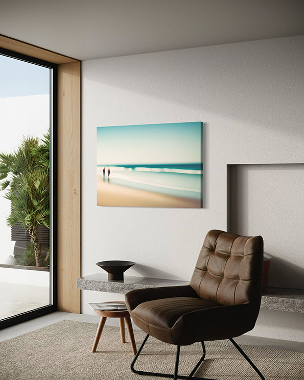Beach Walk unique wall art print.  Two figures in red are off in the distance with a blurred ocean scene creating a peaceful print. artwork in living room hanging next to a window and above a chair.