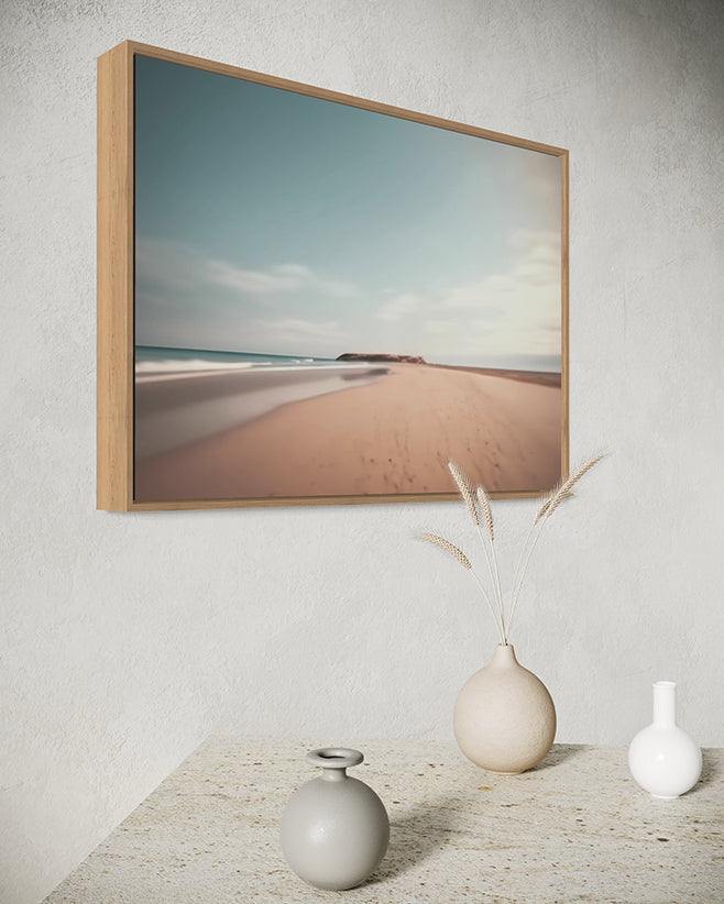 Australian wall art print framed in a canvas float frame featuring a beach scene on a wall with decorative vases below.